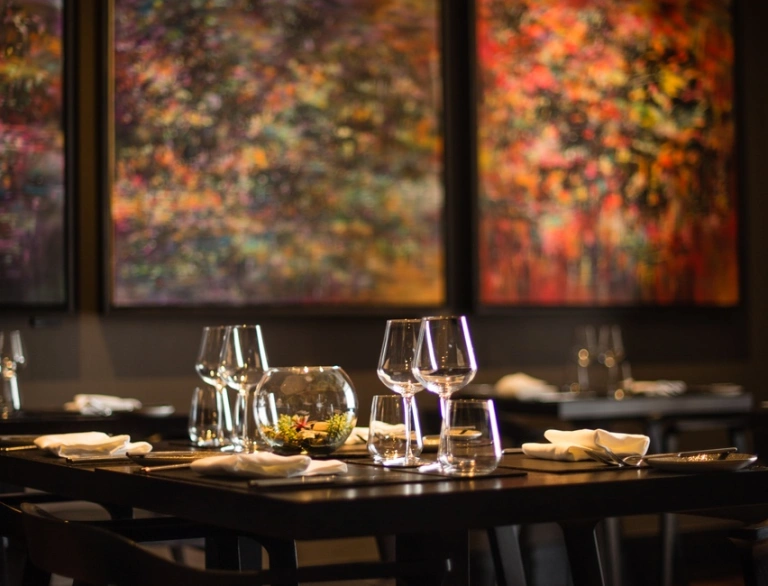 A restaurant in a hotel with colourful artwork in the background.