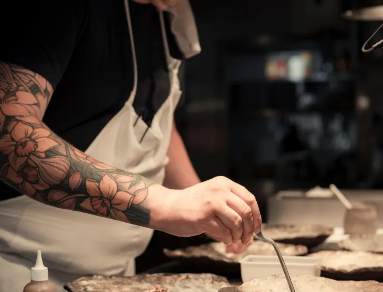A head chef preparing a plate of food.
