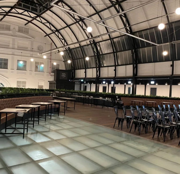 Tables and chairs laid out for meeting space in a Victorian market.
