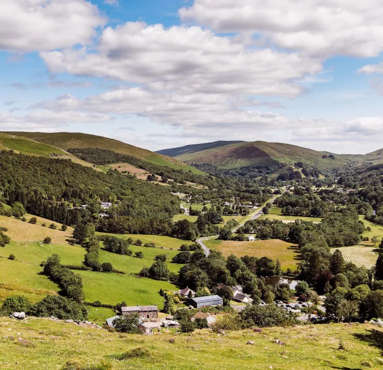 Countryside with blue sky and green mountains.