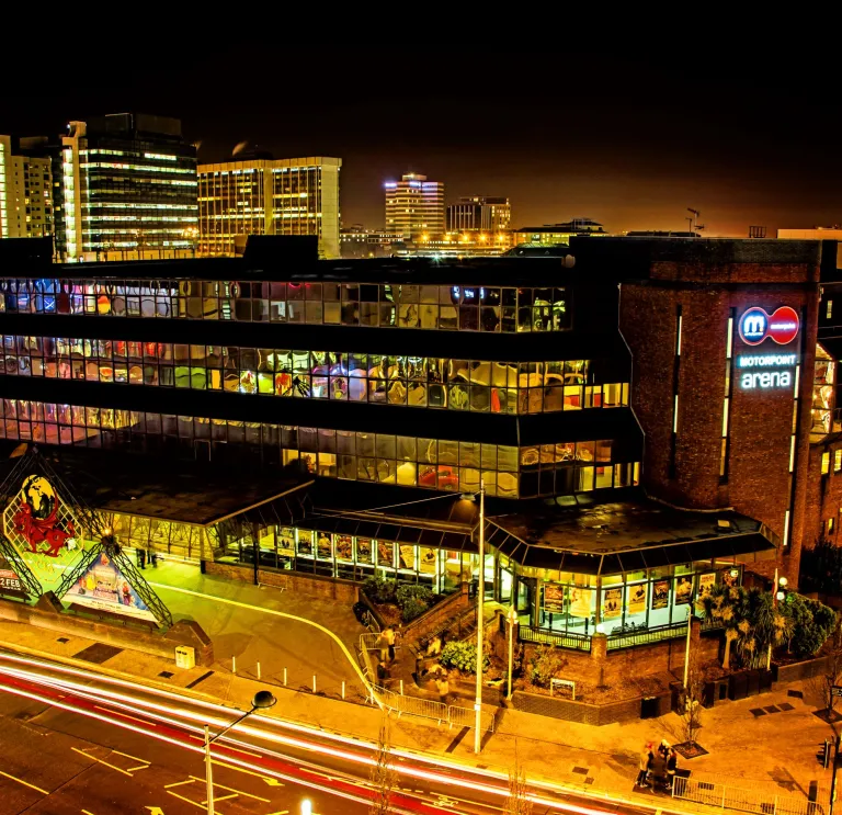 Aerial view of an arena lit up at night time.