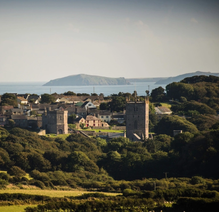 View of a cathedral and countryside with the coast in the background.