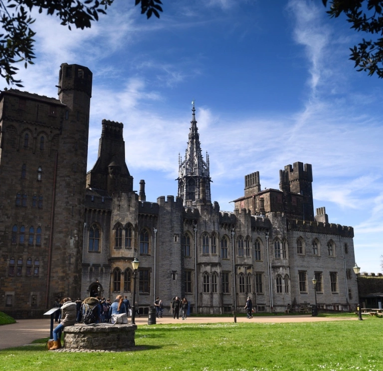 View of the stone build castle apartments and a stone wishing well on the lawn..