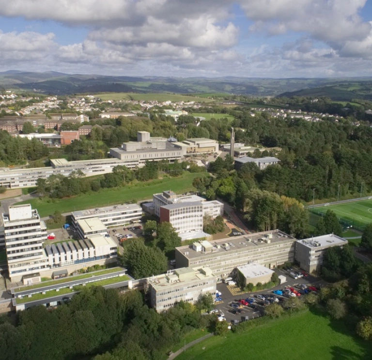 Aerial view of a university building surrounded by playing fields.