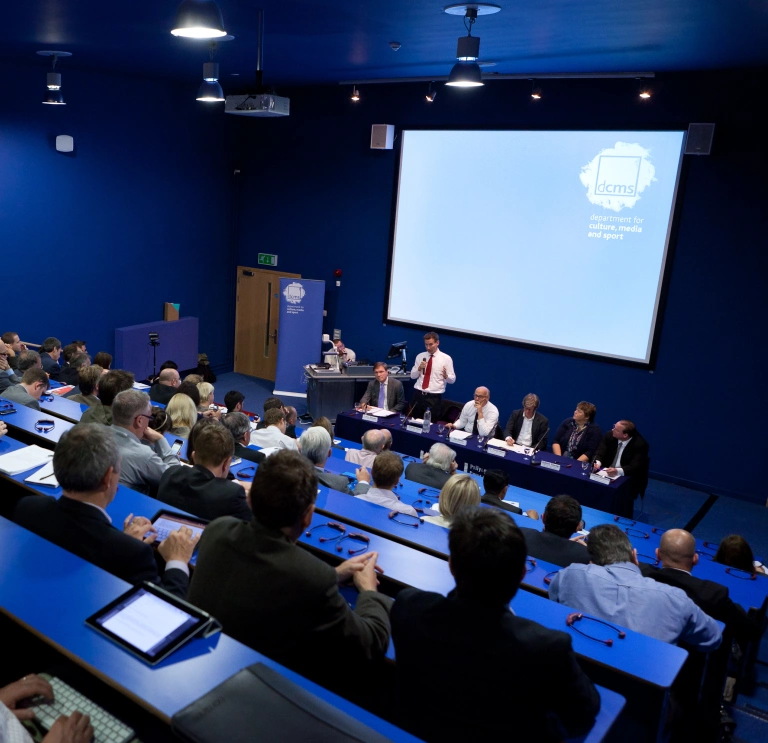A lecture being delivered at a theatre style conference room.
