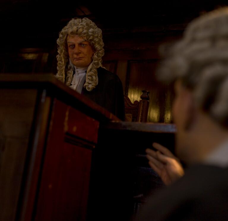Internal museum image showing a judge inside the courthouse with a judges gown and wig on 