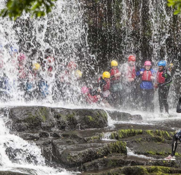 Group of people behind a waterfall 