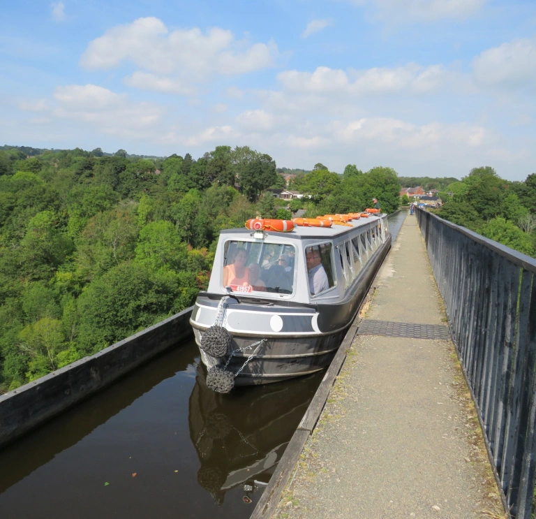 A narrowboat cruising over an aqueduct.