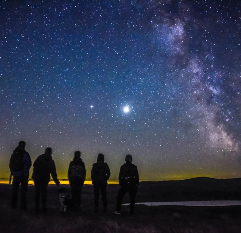 People standing on a mountain watching the stars on the dark Sky reserve 