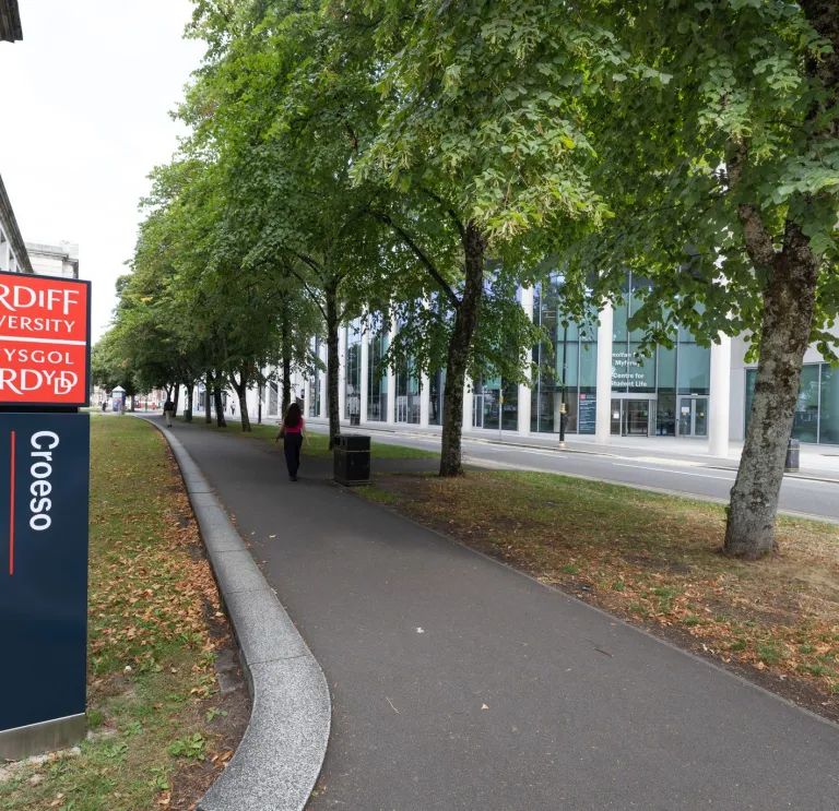 external image of bilingual welcome sign at Cardiff University with trees lining the street  