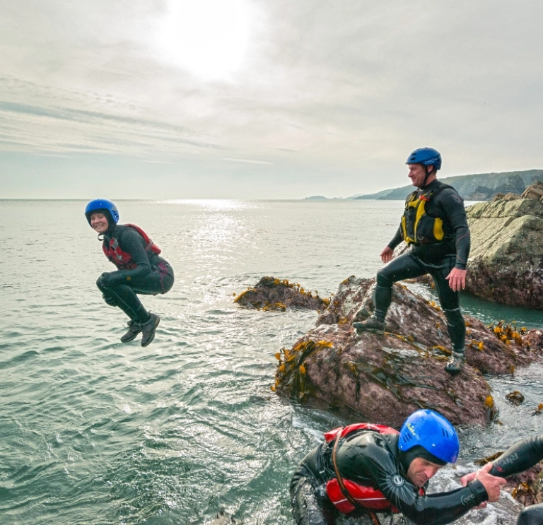 A group coasteering and someone jumping into the sea 