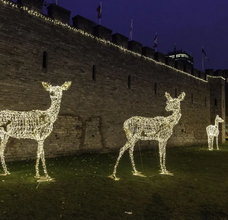 gold lit reindeer decorations outside the castle walls 
