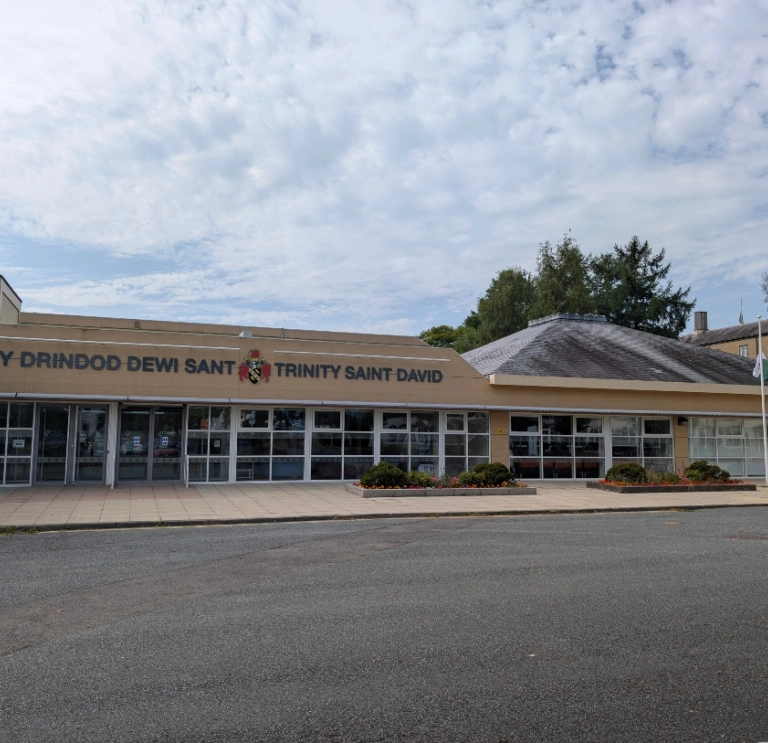 Exterior of the Trinity Saint David building with bilingual Welsh and English signage.
