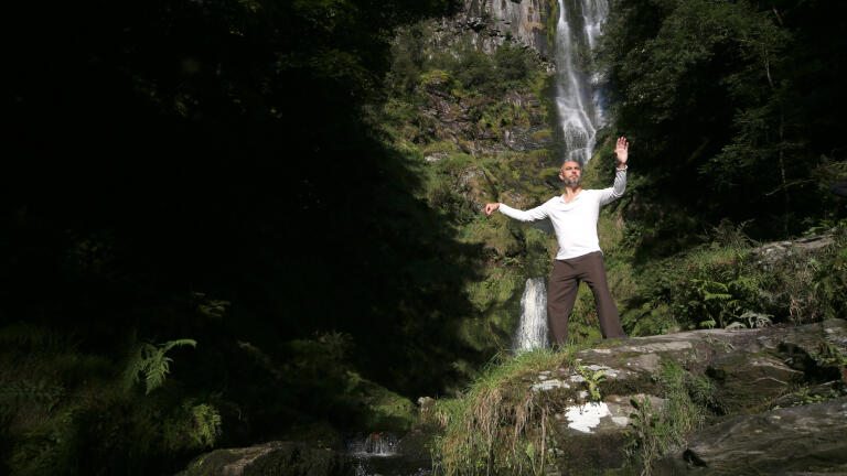 Image of a person in front of a waterfall.