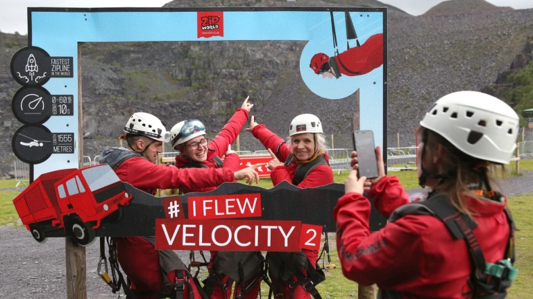 A group posing in a camera frame after travelling down a zip wire.