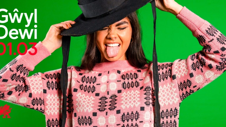 Woman in Welsh hat with her tongue out in Welsh fabric jumper 