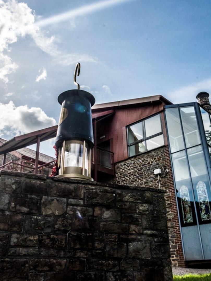 A mining lamp on a wall outside a mining visitor centre.