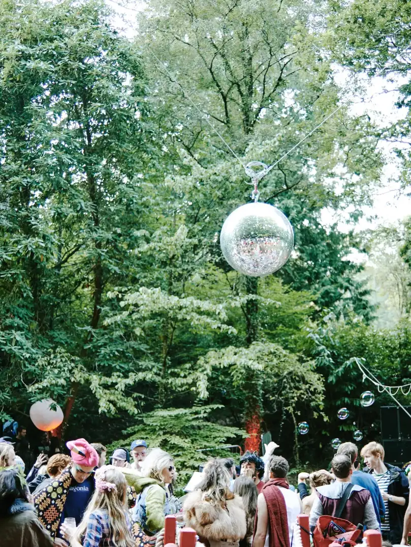 People dancing in the woods at a festival.