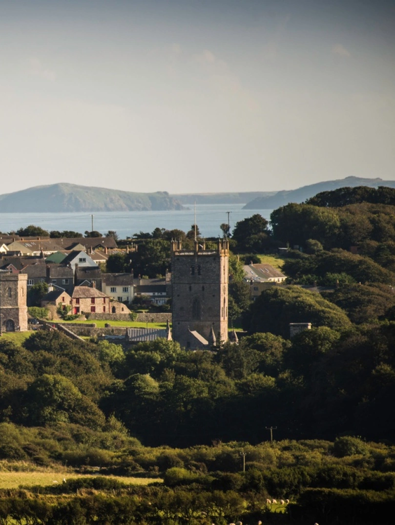 View of a cathedral and countryside with the coast in the background.