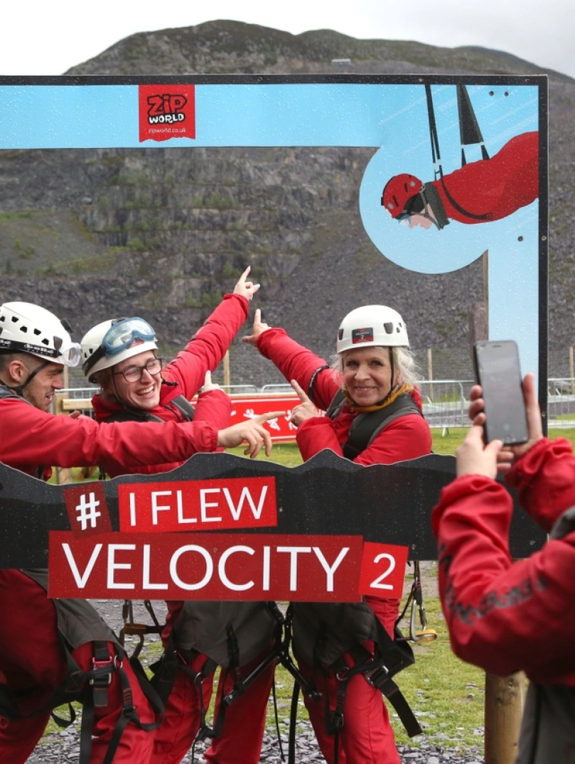 A group posing in a camera frame after travelling down a zip wire.
