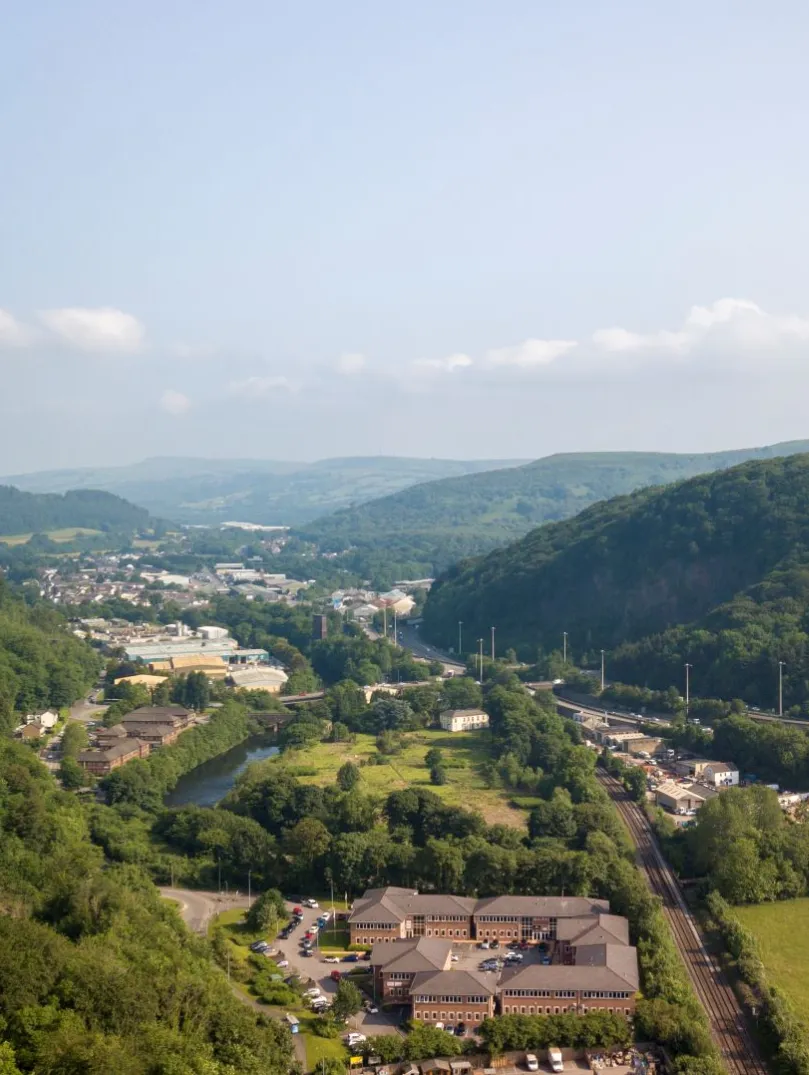 Aerial view of a major road through the valleys with a castle perched on a mountain.