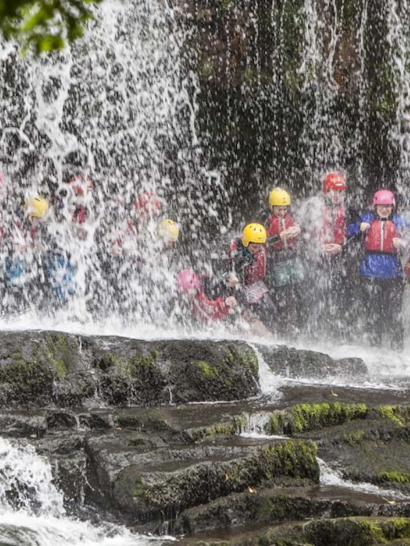 Group of people behind a waterfall 
