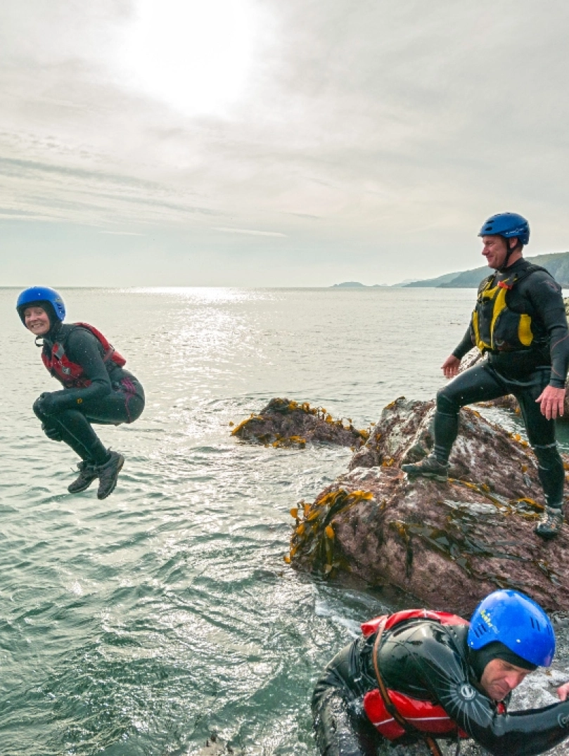 A group coasteering and someone jumping into the sea 