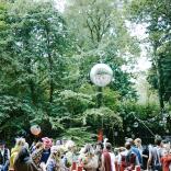 People dancing in the woods at a festival.