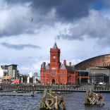 Historic red brick building with clock tower and copper coloured roof building.
