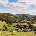 Countryside with blue sky and green mountains.