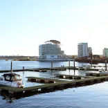 Boats marined on a bay with a hotel in the background.