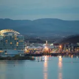 View of Cardiff Bay at dusk with lights reflecting in the water.