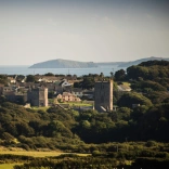 View of a cathedral and countryside with the coast in the background.