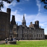 View of the stone build castle apartments and a stone wishing well on the lawn..
