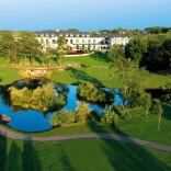Aerial shot of a hotel, lake and golf course.