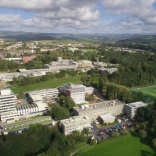 Aerial view of a university building surrounded by playing fields.