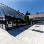Outside Penderyn Distillery Llandundo, glass building and blue sky.