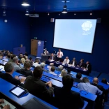 A lecture being delivered at a theatre style conference room.