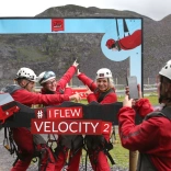 A group posing in a camera frame after travelling down a zip wire.