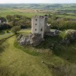 A castle hotel on a hill with the coastline beyond.