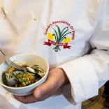 Chef in apron displaying Culinary Association of Wales badge