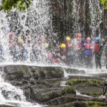 Group of people behind a waterfall
