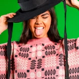 Woman in Welsh hat with her tongue out in Welsh fabric jumper 