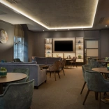 Hilton Cardiff executive lounge features soft blue chairs and wooden tables