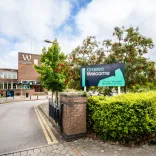 exterior of Wrexham University entrance with croeso welcome sign on hedge