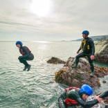 A group coasteering and someone jumping into the sea 