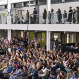 people seated and standing on upper and lower floors of the museum during the conference 
