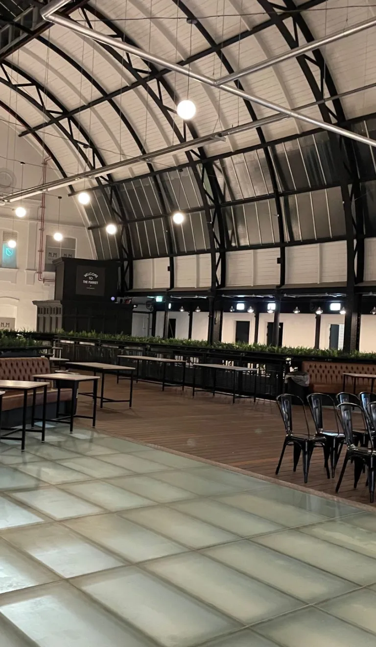 Tables and chairs laid out for meeting space in a Victorian market.